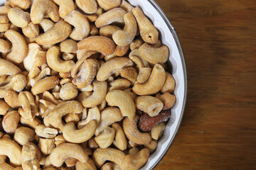 Bowl of Salted Cashews with Wooden Background
