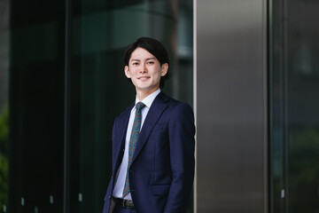 出社する若い男性・マンションのロビー背景・ビジネスイメージ
