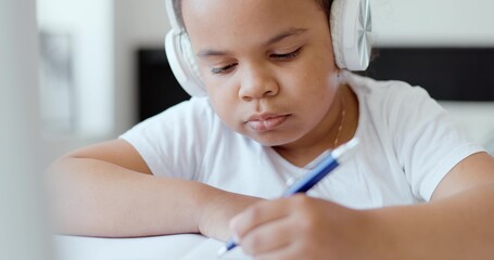 Naklejka premium Afro american kid girl school pupil wearing headphones studying online from home watching web class lesson or listening tutor by video call elearning on pandemic isolation. Children remote education.