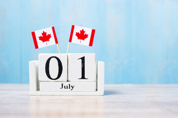 Wooden calendar of July 1st with miniature Canada flags. Canada Day  and happy celebration concepts