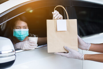 Food delivery courier give meal to woman in her car,Safety food during coronavirus pandemic...