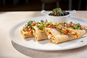 A view of a garnished gourmet chicken quesadilla.