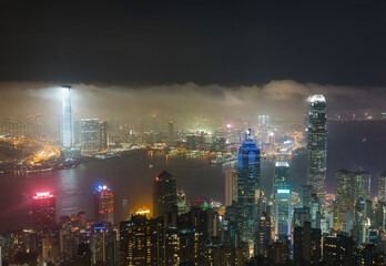 Fototapeta na wymiar Misty night view of Victoria harbor of Hong Kong city in fog