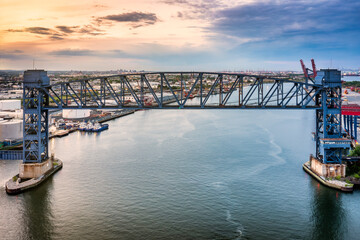 Aerial view of Arthur Kill vertical lift bridge at sunset. Arthur Kill railroad lift bridge connects Elizabethport, New Jersey and the Howland Hook Marine Terminal on Staten Island, New York.
