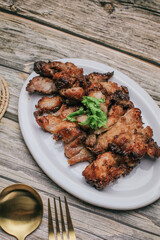 Grilled Pork Neck with Spicy sauce and steamed sticky rice on rustic wooden table, Thai Food.