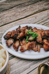 Grilled Pork Neck with Spicy sauce and steamed sticky rice on rustic wooden table, Thai Food.