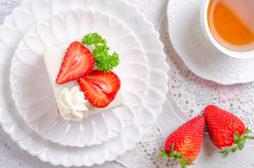 Homemade strawberry cake on a white plate with tea. Top view.