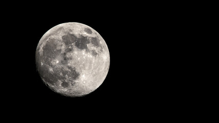 Big full Moon with craters. Isolated black night sky without stars. View in telescope telephoto lens. Astro or astronomy photography. Luna Little planet. Moon is Earth natural satellite. Copy space.