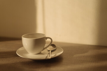 Fototapeta na wymiar White coffee mug on the wooden table warm light