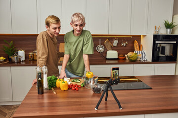 Young homosexual male pair shooting vlog about cooking