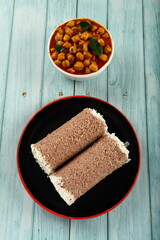 Top view- delicious homemade red rice flour puttu served with chickpeas curry- vegan diet foods.