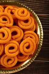 Indian spicy sanck- murukku, muruku, chakli, served in brass palte.