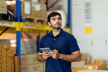 Portrait of warehouse male worker using digital tablet in factory warehouse. Inspection quality...
