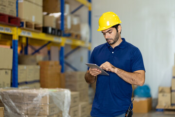 Portrait of warehouse male worker using digital tablet in factory warehouse. Inspection quality...