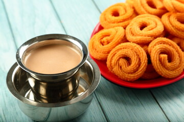 Snack time- delicious crispy fried spicy chakli, murukku served with Indian milk tea.