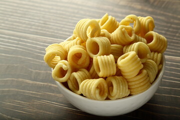 Indian snack foods- Homemade butter murukku, chakli served in ceramic bowl.