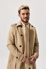 Obraz premium portrait of a blonde in a beige coat and a light background beautiful face trend of the season spring