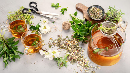 Herbal tea with cups and teapot on light gray backround.