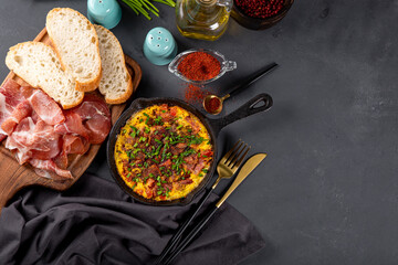 Egg omelet with sausage and seasonings in a cast iron pan top view free space for text