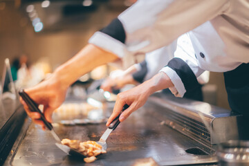 Hand of man take cooking of meat with vegetable grill, Chef cooking wagyu beef in Japanese teppanyaki restaurant