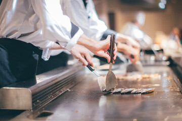 Hand of man take cooking of meat with vegetable grill, Chef cooking wagyu beef in Japanese teppanyaki restaurant