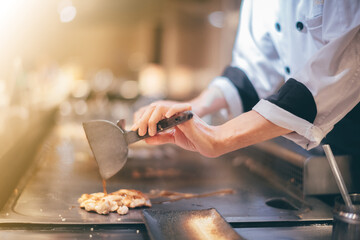 Hand of man take cooking of meat with vegetable grill, Chef cooking wagyu beef in Japanese teppanyaki restaurant