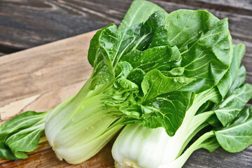Bok choy or Chinese-cabbage with water drop on wooden board and wooden floor..Bok choy is the best leafy green vegetable.