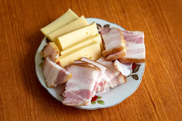 Sliced ham and cheese on a plate close-up.