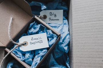 product tags with small business vs big brand texts inside of bigger and smaller delivery parcels, supporting small local businesses