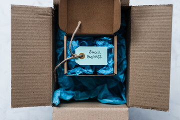 product tag with small business text inside ofsmaller delivery parcel inside of a bigger parcel, supporting small local businesses