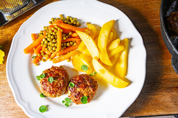 Homemade meatballs with french fries and vegetables