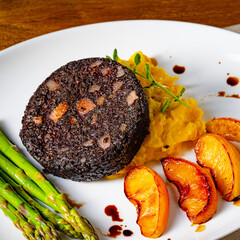 Black pudding with green asparagus and fried apple