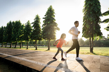 asian father and little daughter do exercises running outdoor. Healthy lifestyle of family with...