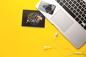 Gift card and laptop on color background