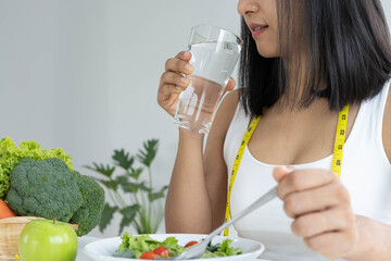 Healthy food. Women plan dieting for slim shape and healthy. Woman eating water, vegetables, salad and tomatoes