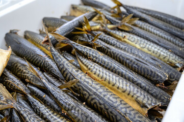 Lots of smoked mackerel carcasses. The fish lies in a heap in a white plastic box.