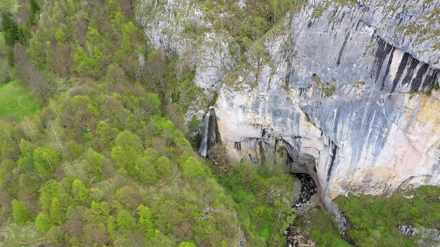  Flying above a waterfall and big cave entrance, Romania, aerial view by drone