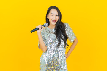 Portrait beautiful young asian woman sing a song with microphone