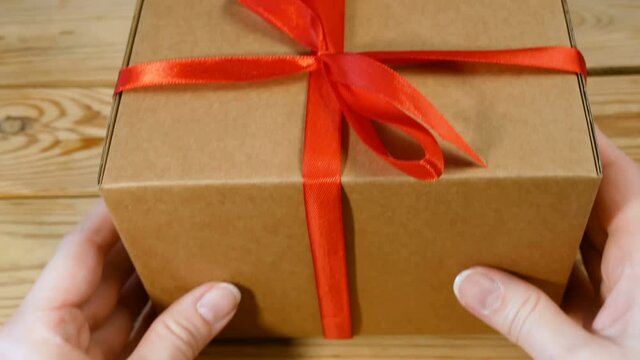 Gift parcel box with ribbon red bow, brown carton parcel, surprise