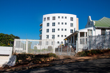 Tall Curved White Residential Building Against Blue Sky