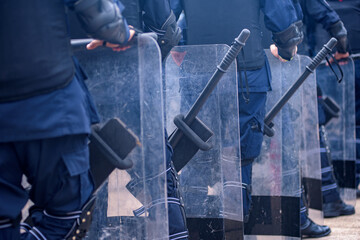 Riot police practice shields and baton