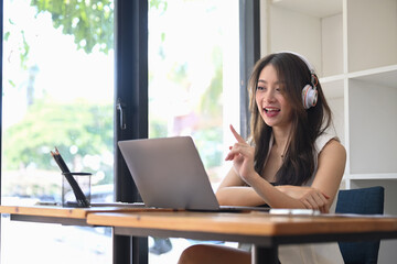 Businesswoman using video call on laptop and discussing work project online.