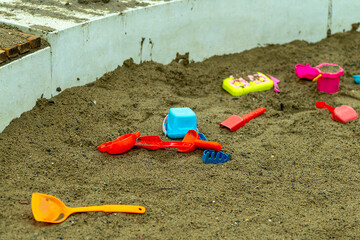 scattered children's sand toys in the sandbox in the park,