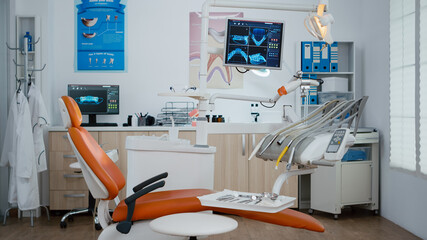 Interior of modern equipped dental office with x ray on monitors, dentist stomatology orthodontic workplace. Zoom in shoot. Medical cabinet for teethcare, treatment clinic