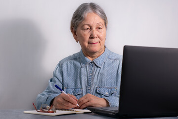 Senior business woman with laptop. Elderly woman working on laptop computer, smiling. Isolated over white background.