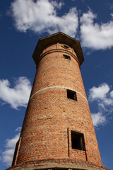 Ruins of an industrial building and a brick tower in the Urals. Tall brick tower and ruins. Majestic ruins in the Urals
