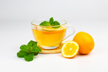 Transparent glass cup with aromatic tea, mint leaves and lemon slice isolated on white background. Part of set.