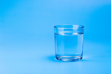 Fresh water in glass on aqua blue background. Part of set.