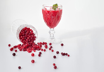 Overturned glass and scattered cranberries. Cranberry smoothie glass