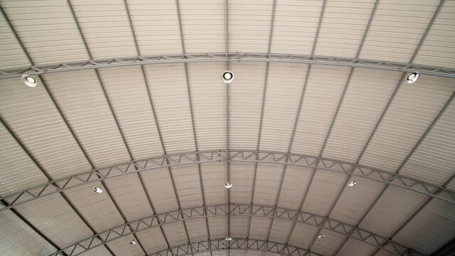 Looking up from under a large, indoor parking facility at the trusses supporting the roof - tilt up